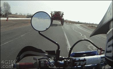Motorcycle-passes-underneath-tractor