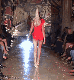 A model tries and fails to walk on the catwalk with high heels