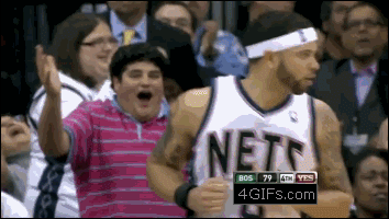 A basketball fan is very excited after a play