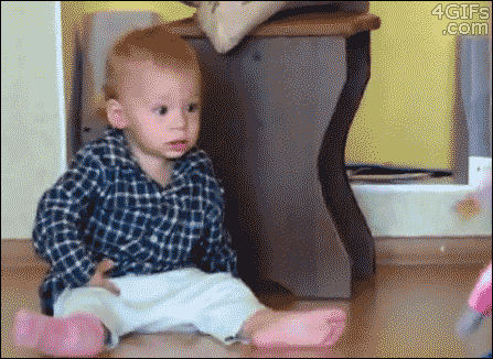 A baby gets scared as a walking toy approaches him