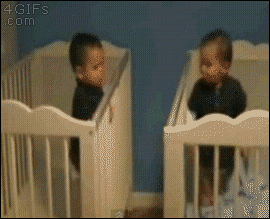 A smart baby climbs over his crib to pull his brother's crib next to his