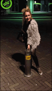 A girl sits on top of a bollard and it appears to go inside her as it gets pushed to the ground