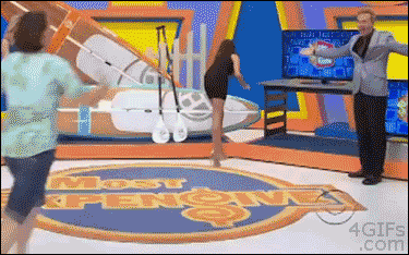 A game show contestant wearing flip flops trips on a rug and takes down the host