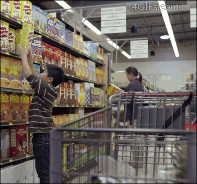 A boy tries to throw a cereal box into the cart but out of nowhere a basketball player denies him