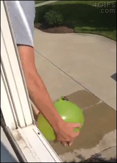 A water balloon is thrown onto a kid's head from a 2nd story window but it fails to break