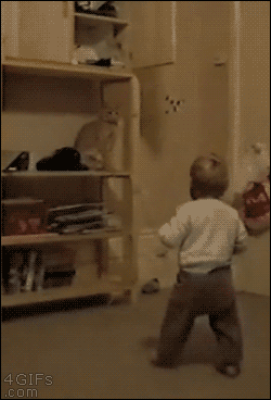 A cat slaps an approaching kid's head and knocks him down