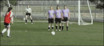 A girl kicks a soccer ball right into the face of an opponent