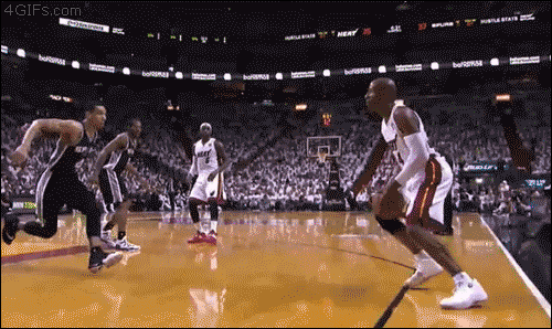 A basketball player tries to block a three point shot but flies out of bounds