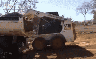A Bobcat loads itself into the the back of a truck