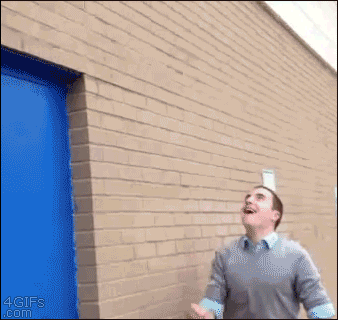 A guy throws a water bottle into the air and it lands upright on a ledge