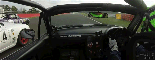 A race car driver pushes in the side mirror of a competitor's car