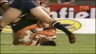 A rugby player sticks his finger in another player's bum