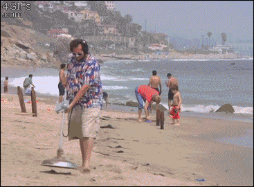 A guy at the beach detects metal with his metal detector