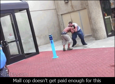 A mall cop walks past a fight