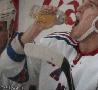 The top of a gatorade bottle pops off into a hockey player's mouth while he's drinking from it