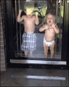 A brother tries to protect his little sister from a hose spraying the door