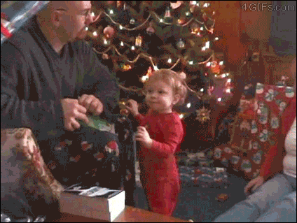 A man accidentally knocks down a baby while opening a present