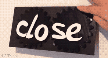 A sign spins so that it can say both open and close