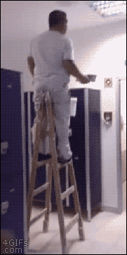 A man walks sideways while on a ladder