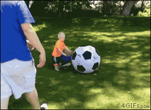 A dad knocks his kids down with a large soccer ball