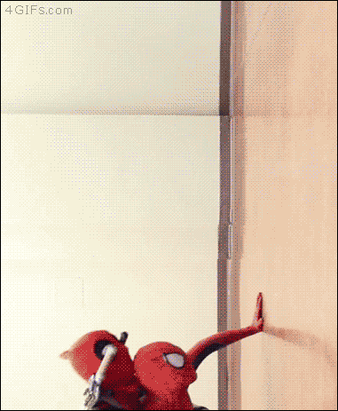 Deadpool and Spiderman are passed on a wall by Spiderdog