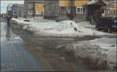 A guy walking into snow suddenly falls into a huge sinkhole