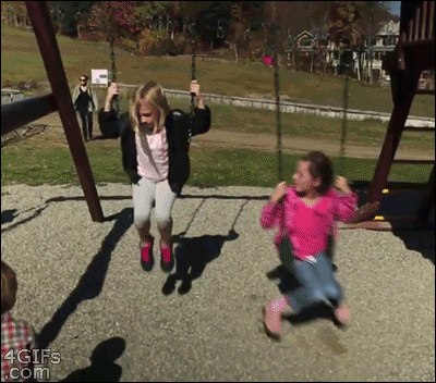 A boy runs in front of a girl swinging and pays the price